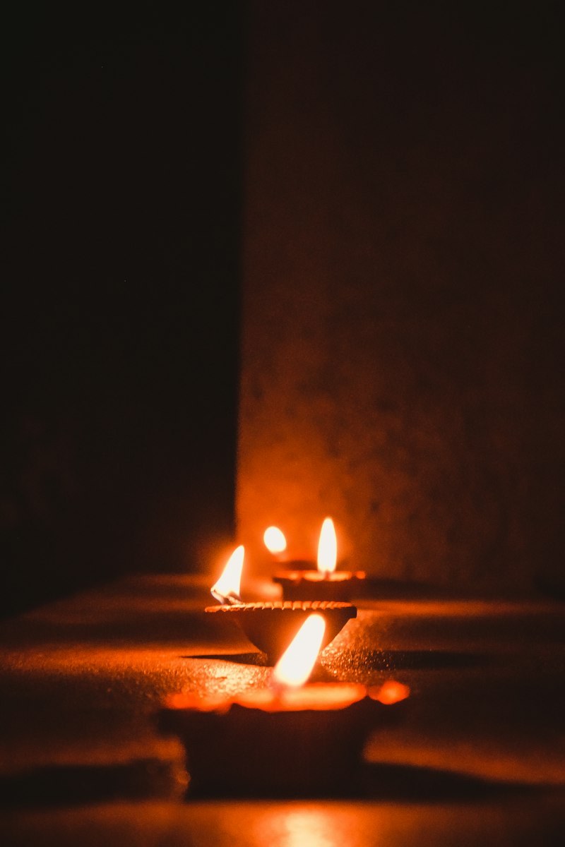 Lit sacred earthen diyas glowing in the home puja ghar